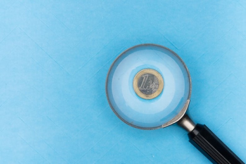 magnifying glass over 1 euro coin